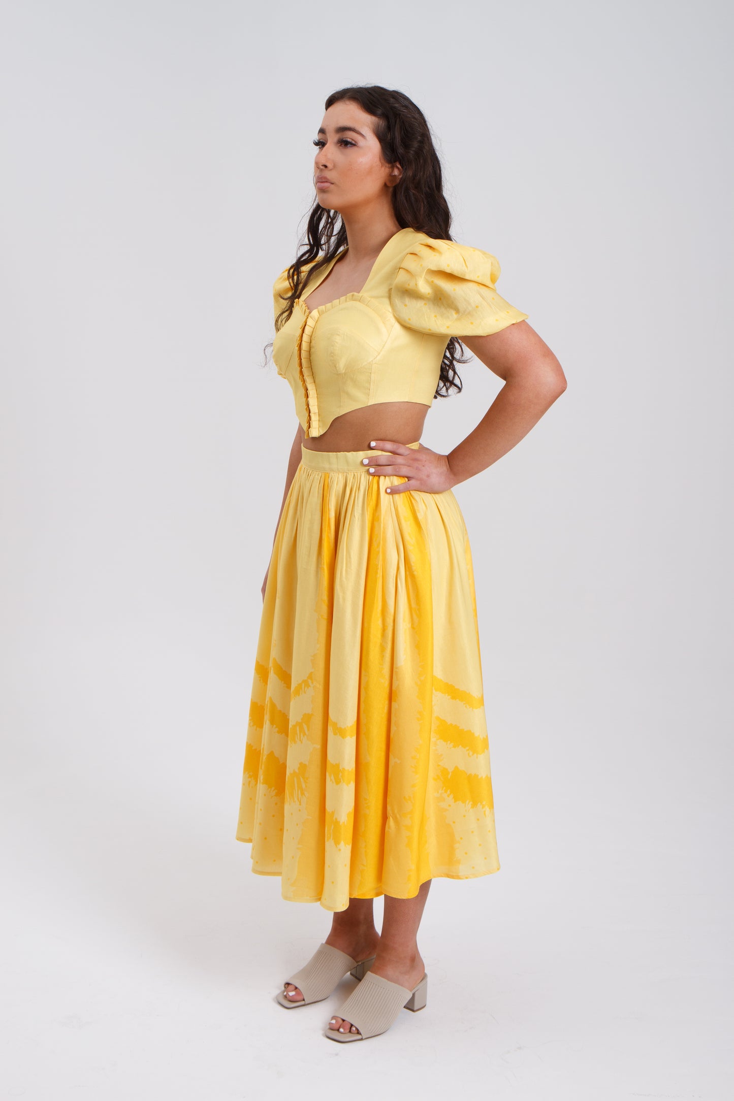 PRODUCT DESCRIPTION Premium silk cotton linen, Daffodil-Yellow unique 2-piece midi dress with short puff sleeves exclusive to MAZASHIE. Sweetheart neck, crop top with shirred back and bra-cut detail. Placement prints on the voluminous skirt and polka-dotted puff sleeves. The elasticated skirt waistband makes a perfect fit. The shirred back band makes a perfect fit. Invisible back zip closure at skirt. Side seam concealed pockets. Hooks and eyes closure at front.