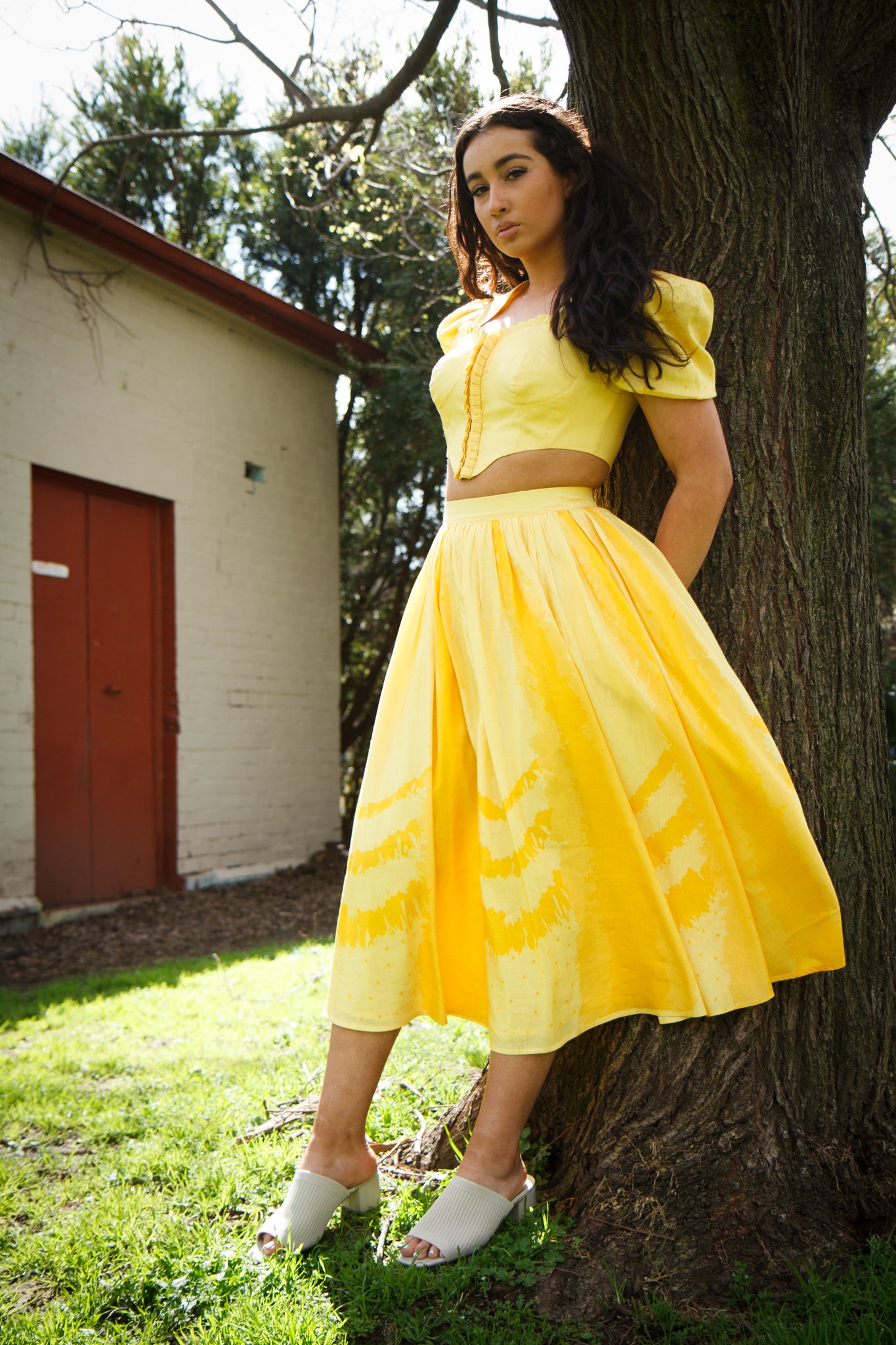 PRODUCT DESCRIPTION Premium silk cotton linen, Daffodil-Yellow unique 2-piece midi dress with short puff sleeves exclusive to MAZASHIE. Sweetheart neck, crop top with shirred back and bra-cut detail. Placement prints on the voluminous skirt and polka-dotted puff sleeves. The elasticated skirt waistband makes a perfect fit. The shirred back band makes a perfect fit. Invisible back zip closure at skirt. Side seam concealed pockets. Hooks and eyes closure at front.