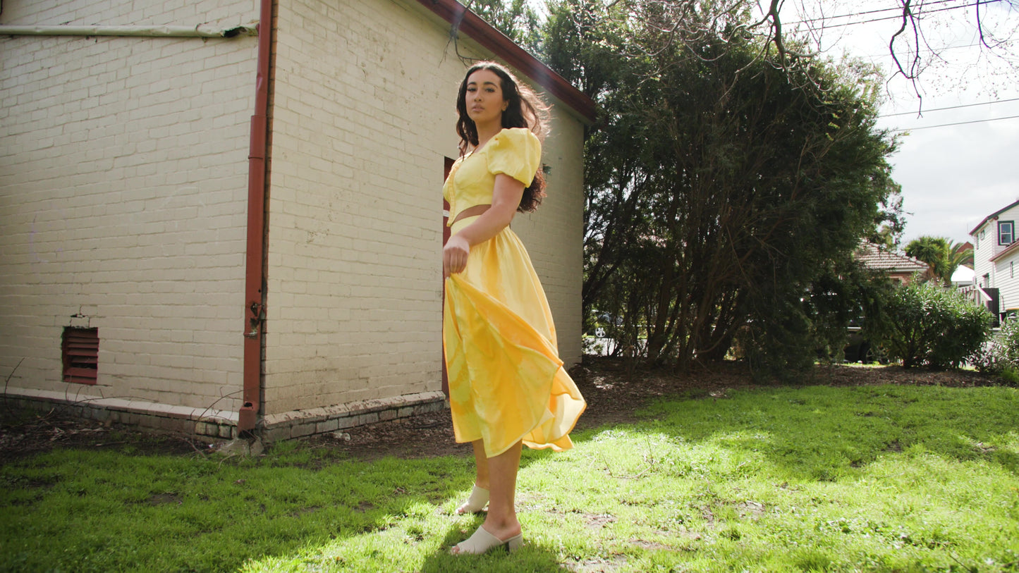 PRODUCT DESCRIPTION   Premium silk cotton linen, Daffodil-Yellow unique 2-piece midi dress with short puff sleeves exclusive to MAZASHIE.  Sweetheart neck, crop top with shirred back and bra-cut detail.  Placement prints on the voluminous skirt and polka-dotted puff sleeves.  The elasticated skirt waistband makes a perfect fit.  The shirred back band makes a perfect fit.  Invisible back zip closure at skirt.  Side seam concealed pockets.  Hooks and eyes closure at front.