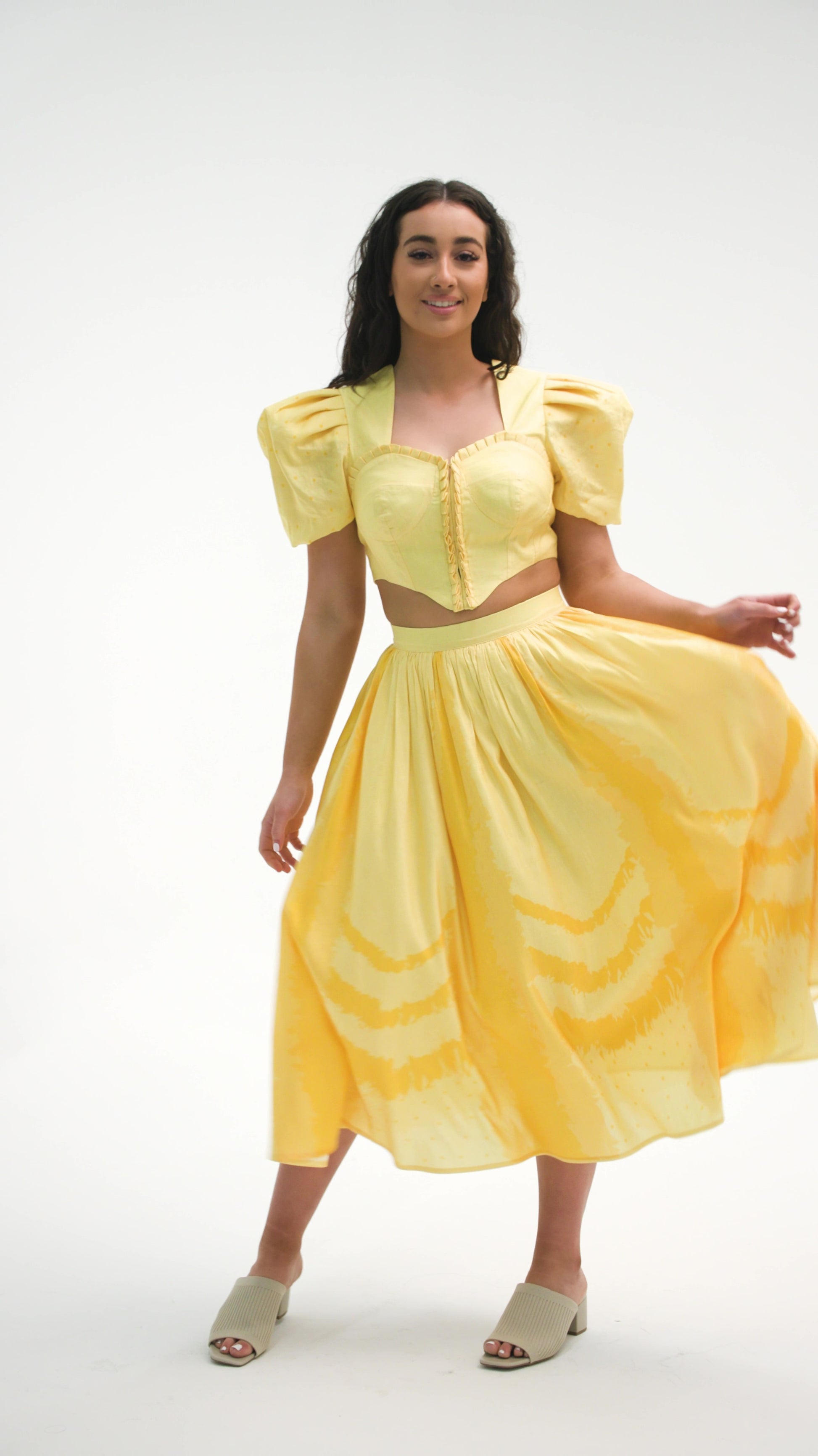 PRODUCT DESCRIPTION   Premium silk cotton linen, Daffodil-Yellow unique 2-piece midi dress with short puff sleeves exclusive to MAZASHIE.  Sweetheart neck, crop top with shirred back and bra-cut detail.  Placement prints on the voluminous skirt and polka-dotted puff sleeves.  The elasticated skirt waistband makes a perfect fit.  The shirred back band makes a perfect fit.  Invisible back zip closure at skirt.  Side seam concealed pockets.  Hooks and eyes closure at front.