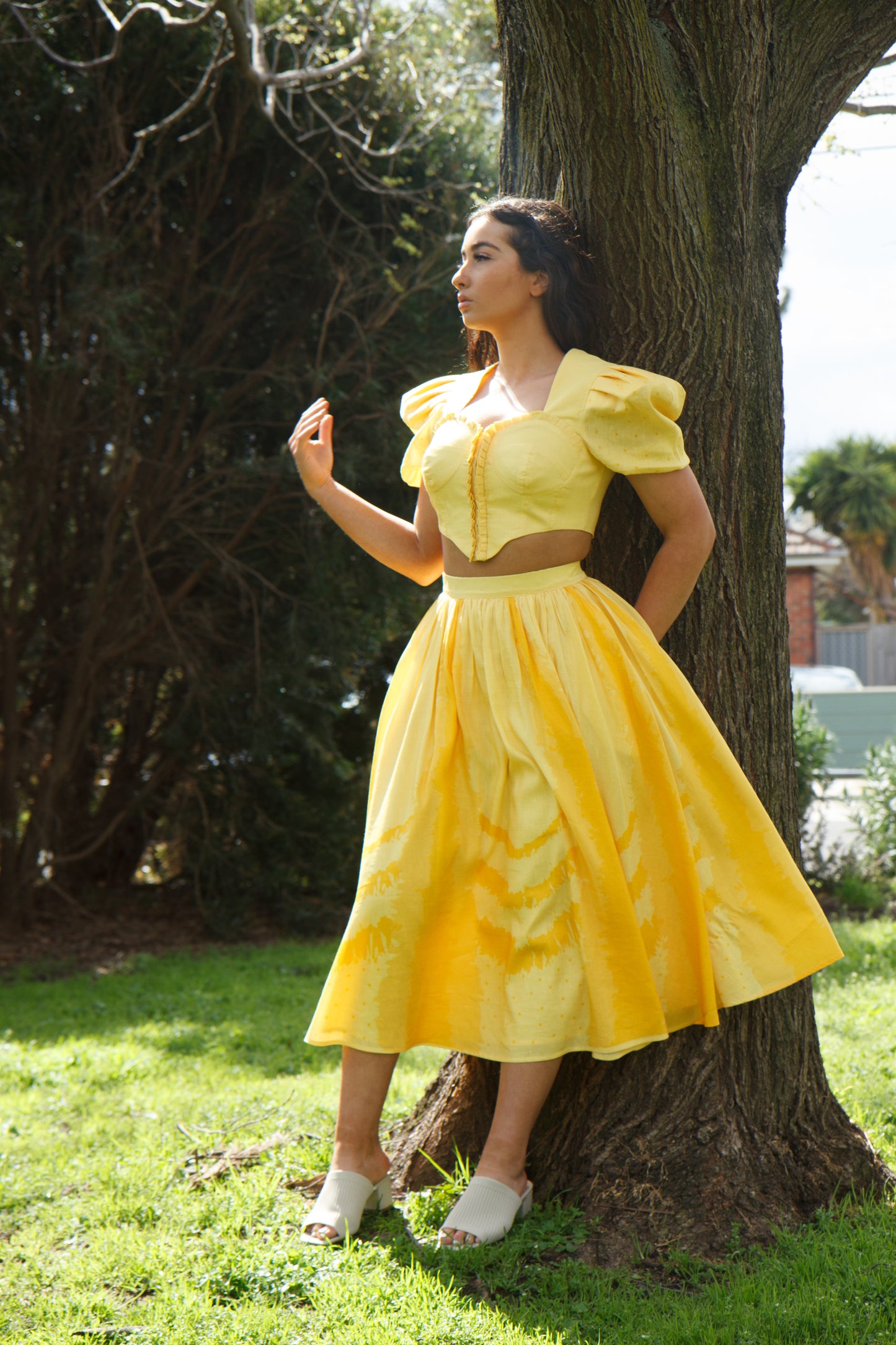 PRODUCT DESCRIPTION   Premium silk cotton linen, Daffodil-Yellow unique 2-piece midi dress with short puff sleeves exclusive to MAZASHIE.  Sweetheart neck, crop top with shirred back and bra-cut detail.  Placement prints on the voluminous skirt and polka-dotted puff sleeves.  The elasticated skirt waistband makes a perfect fit.  The shirred back band makes a perfect fit.  Invisible back zip closure at skirt.  Side seam concealed pockets.  Hooks and eyes closure at front.