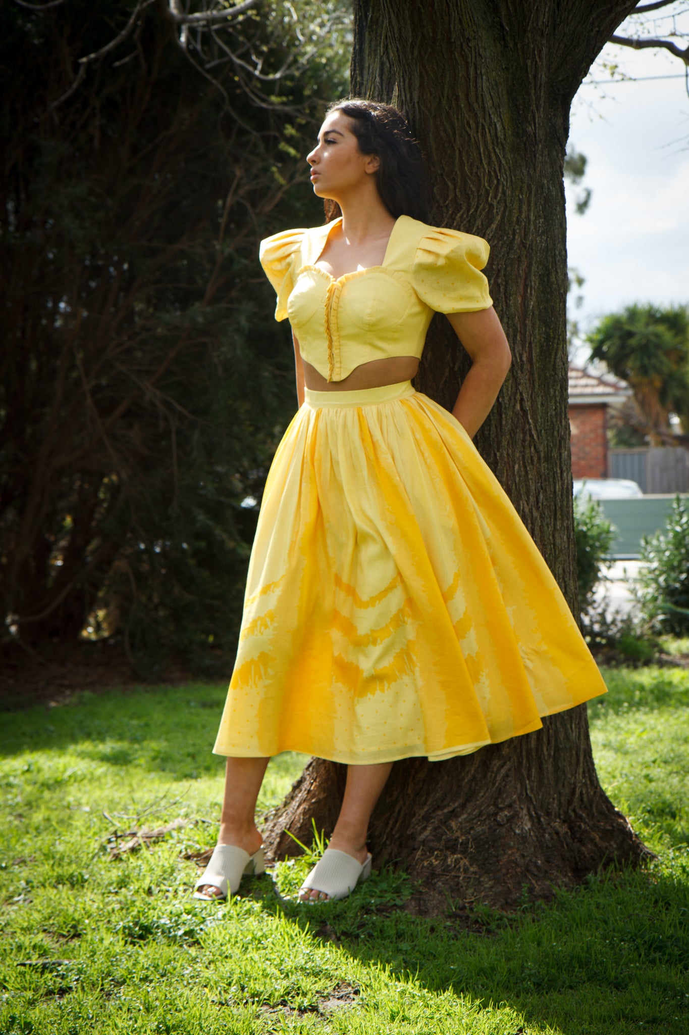 PRODUCT DESCRIPTION   Premium silk cotton linen, Daffodil-Yellow unique 2-piece midi dress with short puff sleeves exclusive to MAZASHIE.  Sweetheart neck, crop top with shirred back and bra-cut detail.  Placement prints on the voluminous skirt and polka-dotted puff sleeves.  The elasticated skirt waistband makes a perfect fit.  The shirred back band makes a perfect fit.  Invisible back zip closure at skirt.  Side seam concealed pockets.  Hooks and eyes closure at front.